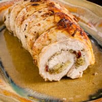 A rolled and stuffed pork loin roast on a platter.