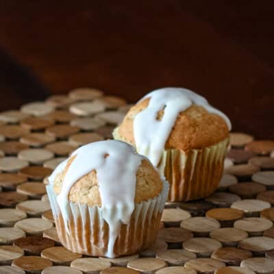 Two banana cupcakes with drizzled icing.