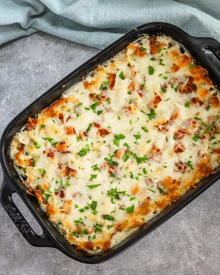 A baking dish with chicken bacon ranch casserole topped with parsley garnish.
