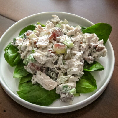 A lettuce-lined plate of chicken salad with grapes.