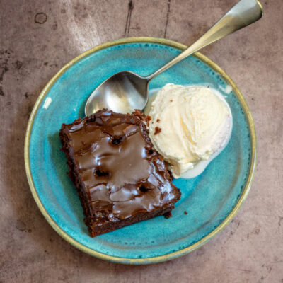 Chocolate cake with a scoop of ice cream in a dessert dish.