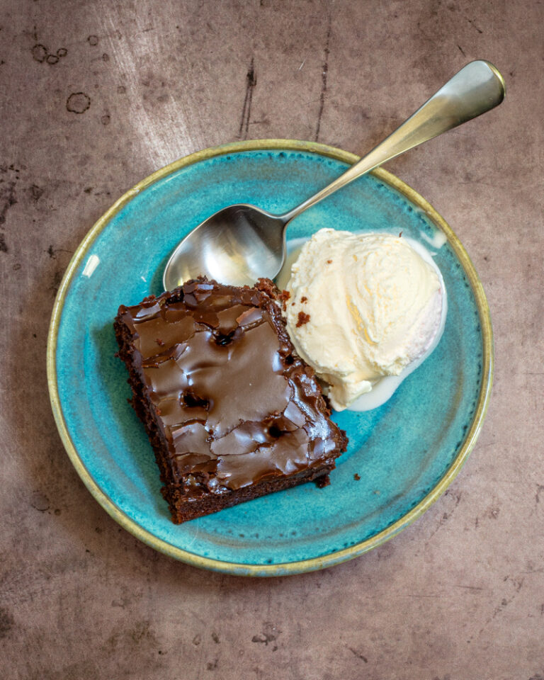 Chocolate cake with a scoop of ice cream in a dessert dish.