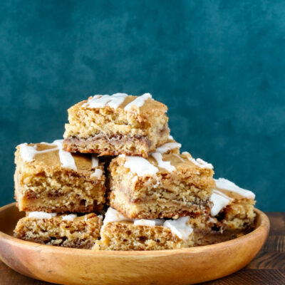 A stack of cinnamon roll blondies, cut to show the lovely cinnamon swirls.