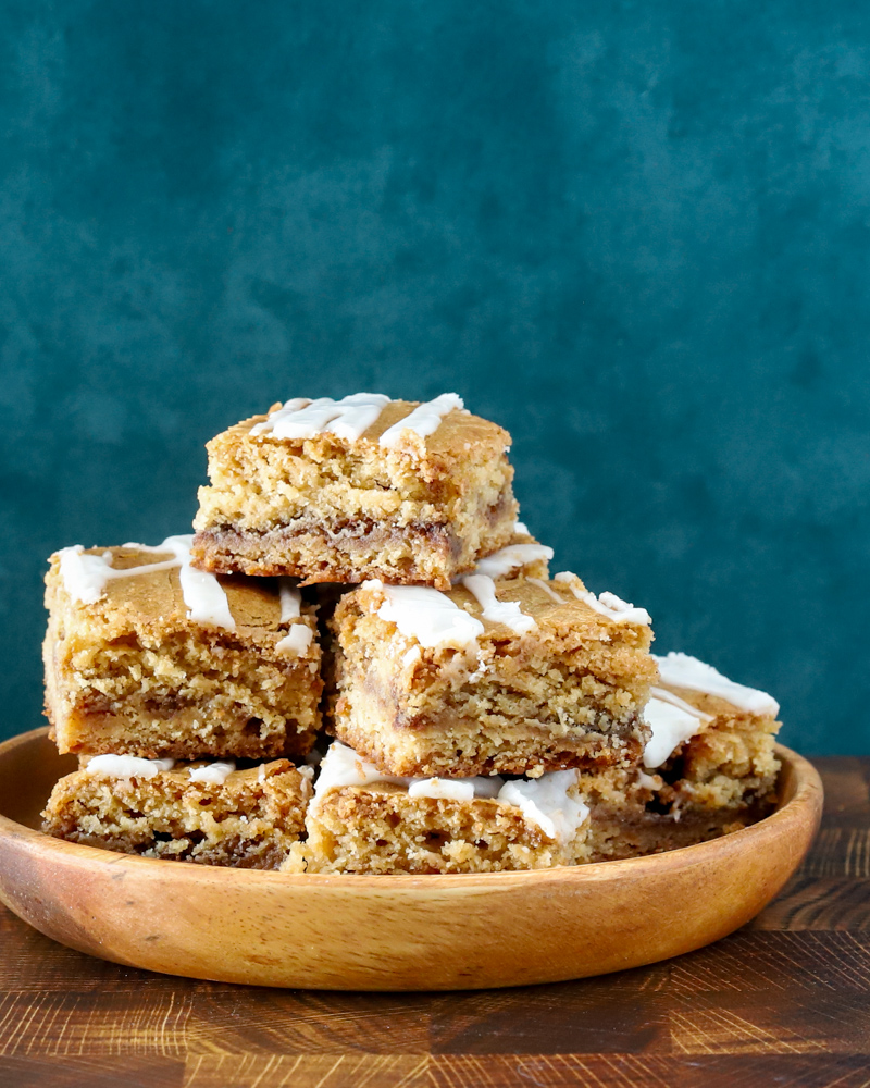 A stack of cinnamon roll blondies, cut to show the lovely cinnamon swirls.