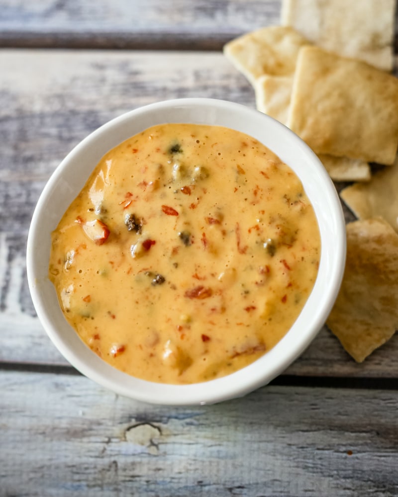A bowl of Rotel dip with crackers beside it.