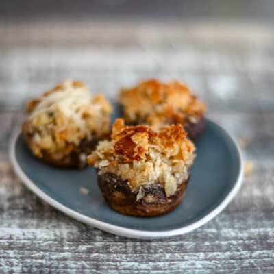 Crab stuffed mushrooms on a small appetizer plate.