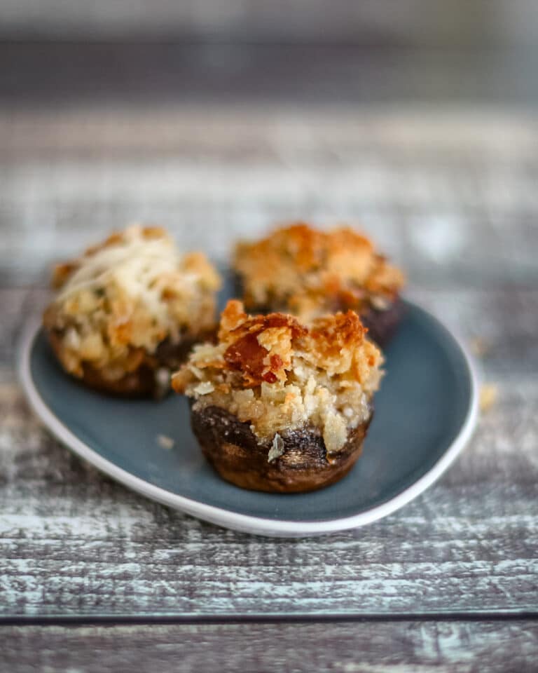 Crab stuffed mushrooms on a small appetizer plate.
