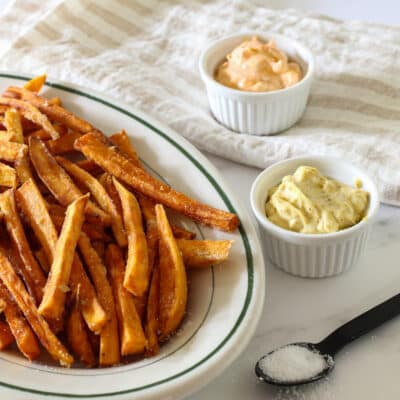Sweet potato fries with curry mayo and Sriracha mayo in ramekins for dipping.