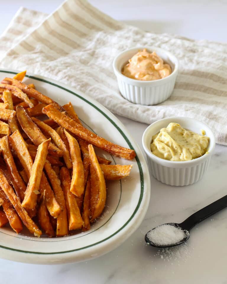 Sweet potato fries with curry mayo and Sriracha mayo in ramekins for dipping.