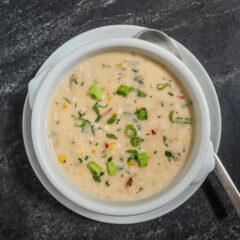 A bowl of slow cooker chicken chowder garnished with green onions.