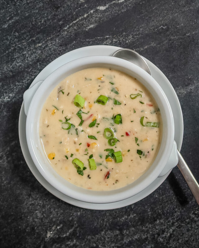 A bowl of slow cooker chicken chowder garnished with green onions.