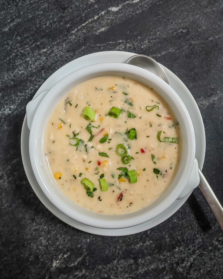 A bowl of slow cooker chicken chowder garnished with green onions.