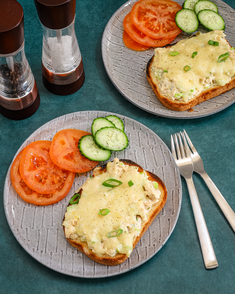 Tuna melt sandwiches, open-faced, with sliced tomatoes and cukes on the side.