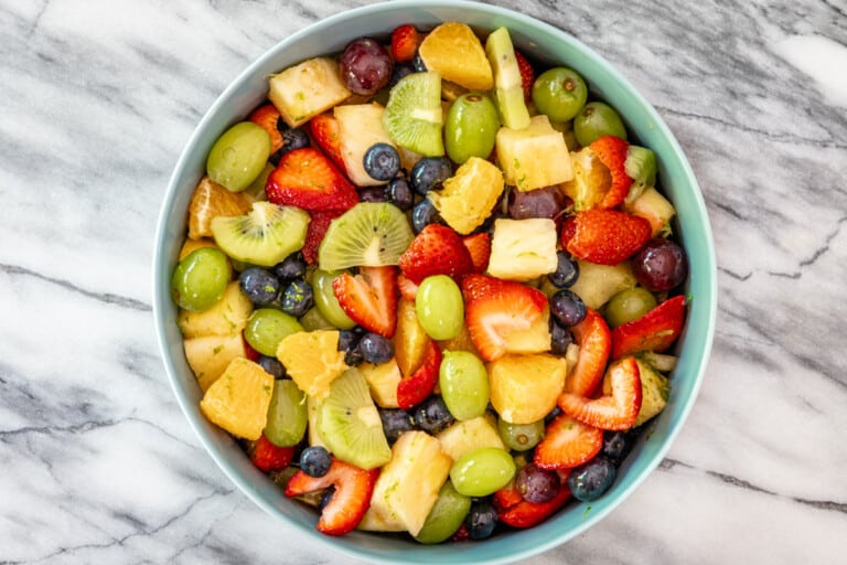 A fresh fruit salad in a large serving bowl.