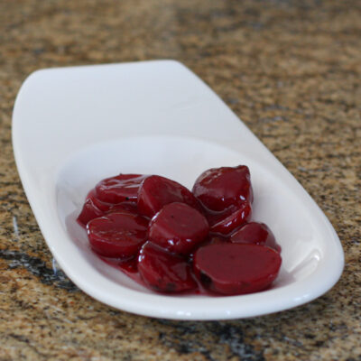 Sweet and sour Harvard beets on a small plate.