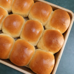 Baked homemade dinner rolls in the baking pan.
