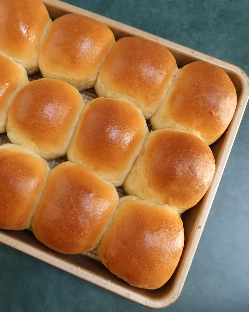 Baked homemade dinner rolls in the baking pan.