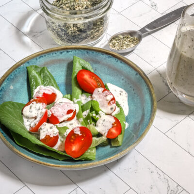Homemade buttermilk ranch dressing on a small salad with the dry mix on the side.