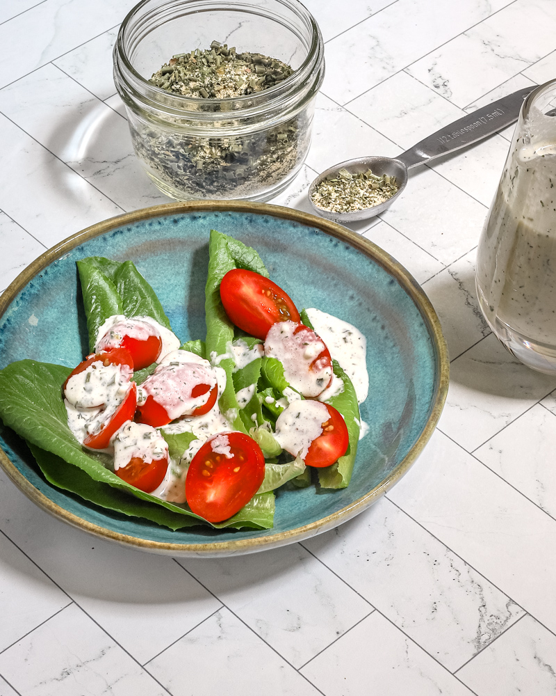 Homemade buttermilk ranch dressing on a small salad with the dry mix on the side.