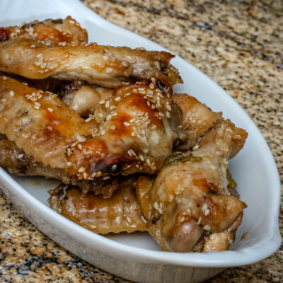 A small serving plate with honey garlic chicken wings.