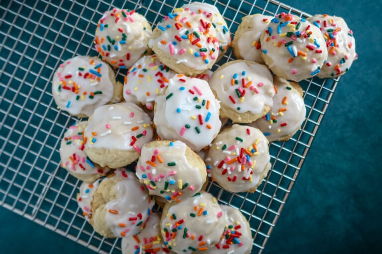 Iced ricotta cookies on a cooling rack.