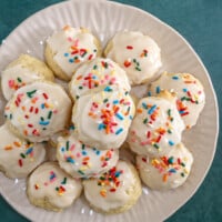 Iced ricotta cookies on a serving plate.