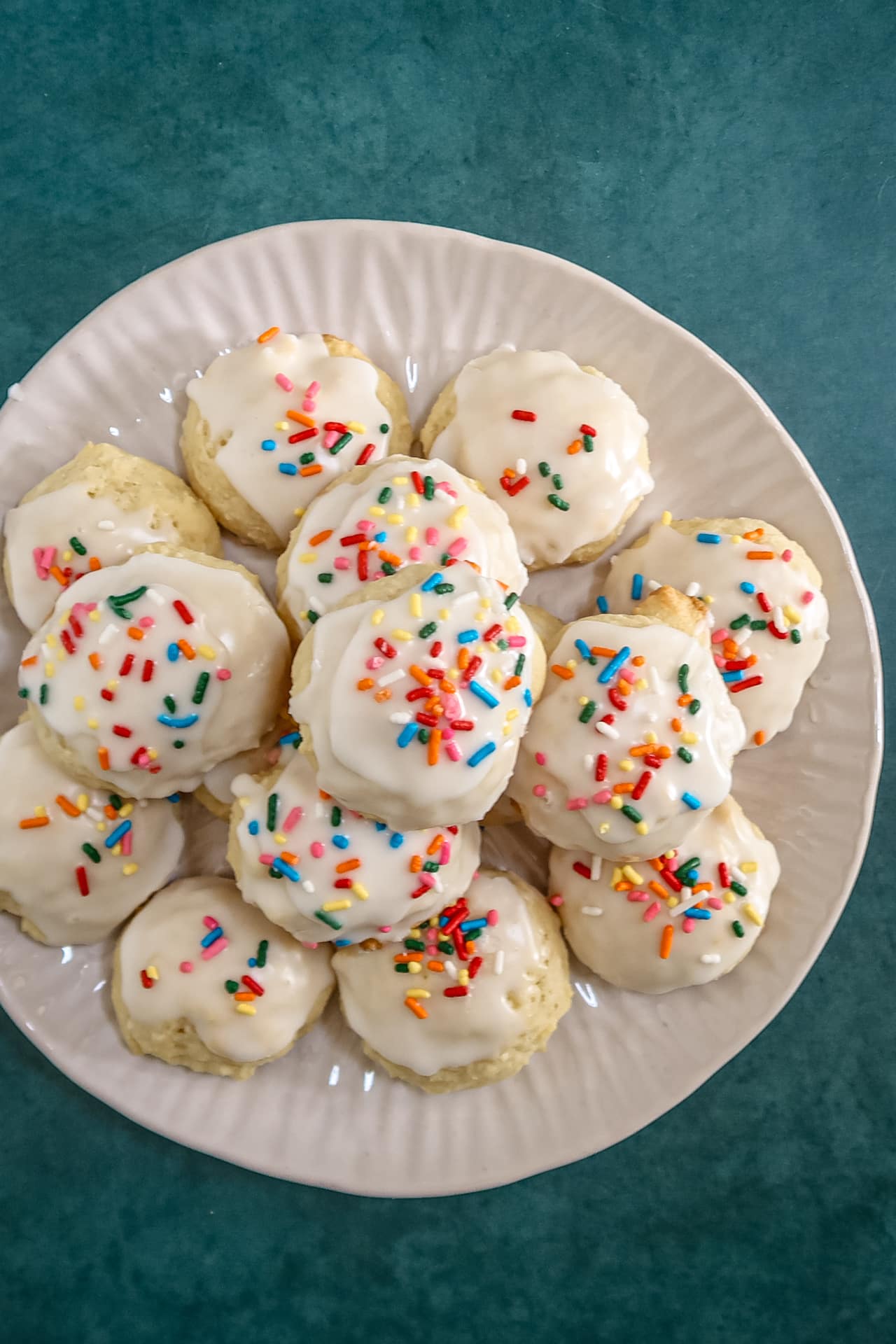Iced ricotta cookies on a serving plate.