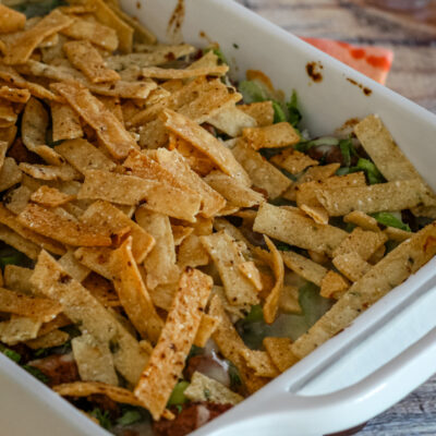 Taco bake in a baking dish with tortilla strips for topping.