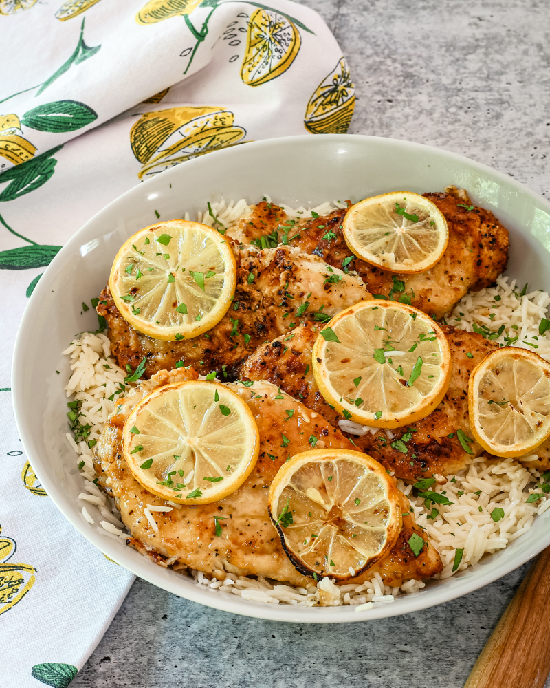 A serving dish with lemon pepper chicken on rice