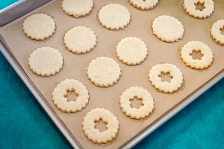 A cookie sheet with linzer cookie cut-outs.