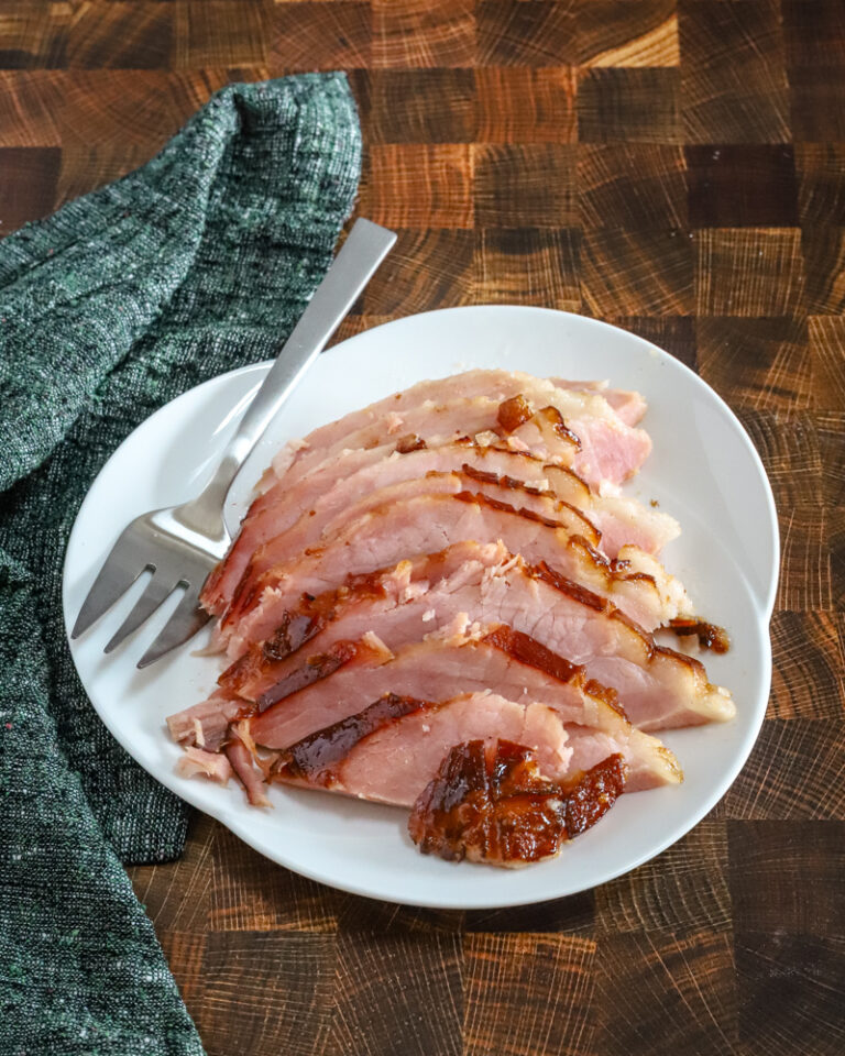 Sliced maple and brown sugar glazed ham on a serving platter.