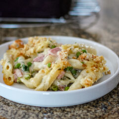 Penne pasta in a creamy sauce with ham, peas, and breadcrumb topping.