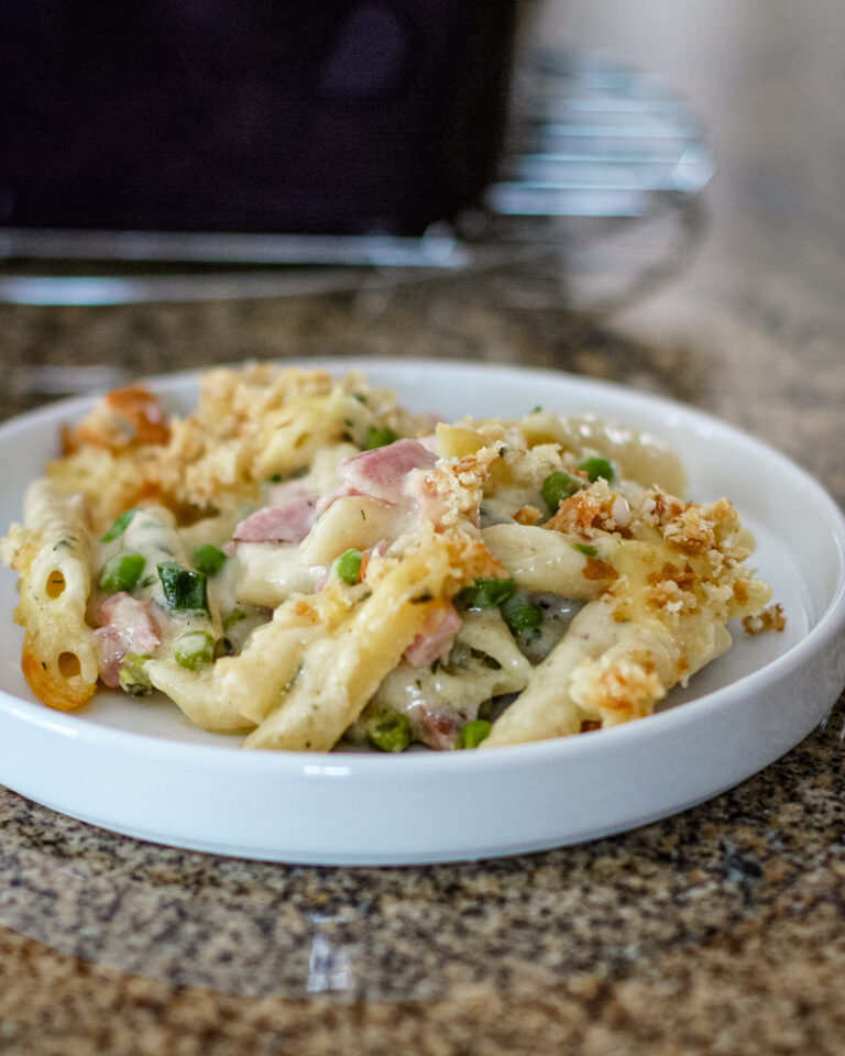 Penne pasta in a creamy sauce with ham, peas, and breadcrumb topping.