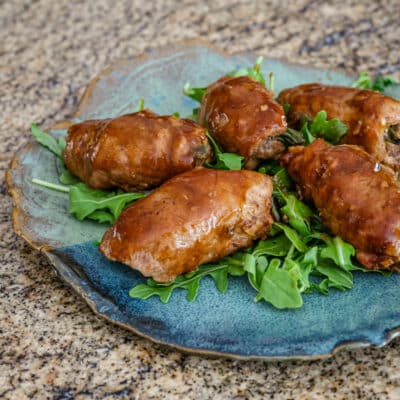 Pork tenderloin and green onion wraps on arugula.