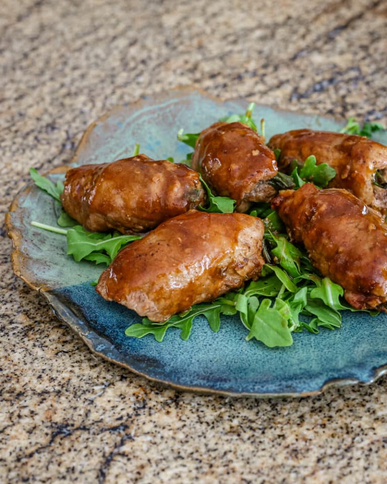 Pork tenderloin and green onion wraps on arugula.
