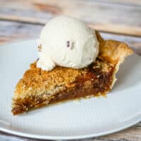 Shoe fly pie on a white plate with ice cream.