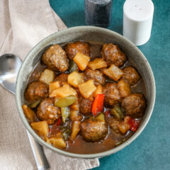 Slow cooker sweet and sour meatballs with bell pepper and pineapple chunks.