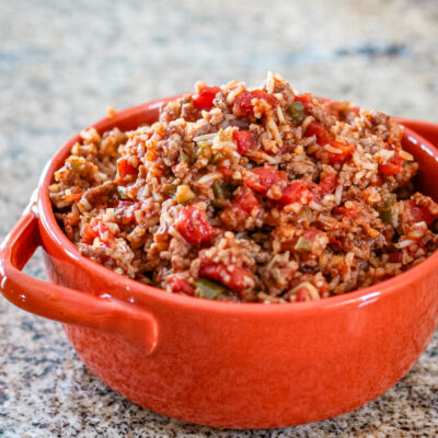 Spanish rice in an orange serving bowl.