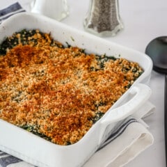 A spinach casserole in a baking dish with crumb topping.