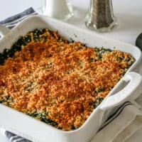 A spinach casserole in a baking dish with crumb topping.