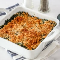 A spinach casserole in a baking dish with crumb topping.