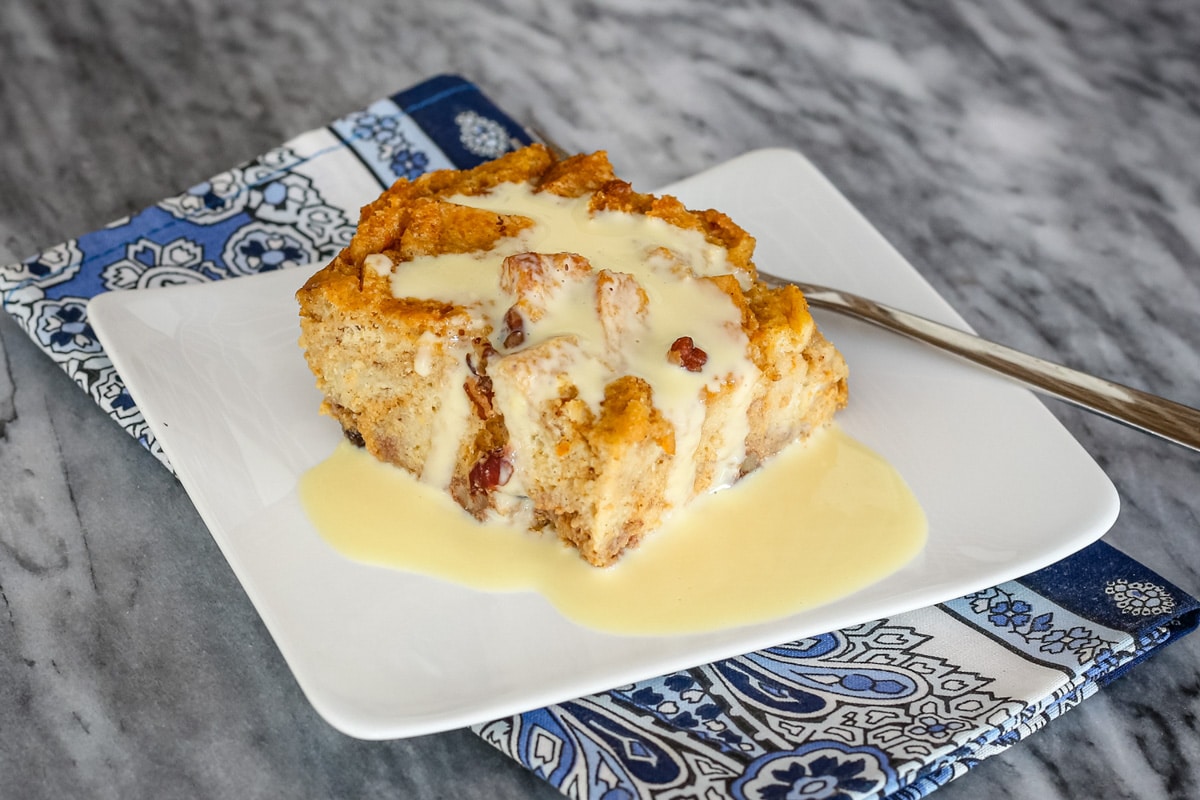 A slice of sweet potato bread pudding with vanilla sauce