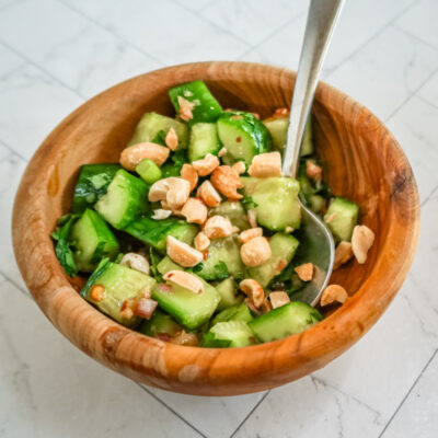 A Thai style cucumber salad in a bowl with spoon.