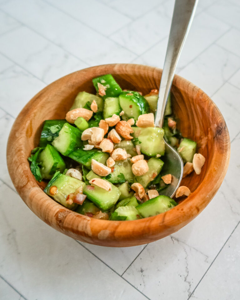 A Thai style cucumber salad in a bowl with spoon.