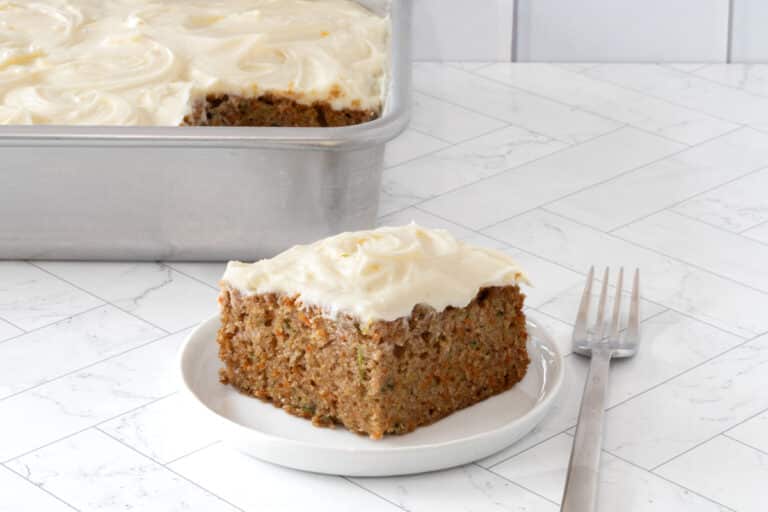 A slice of zucchini carrot cake on a plate with fork.