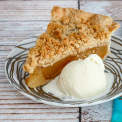 A slice of apple crumble pie with ice cream.