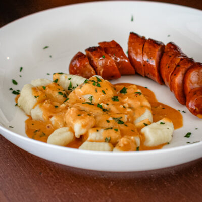 homemade gnocchi on a plate with andouille sausage and a sauce