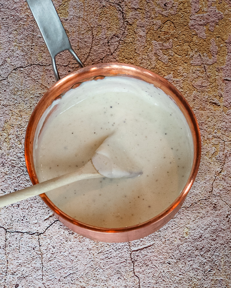 A basic bechamel sauce in a copper pot.