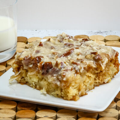 a slice of Cajun cake on a plate with a glass of milk