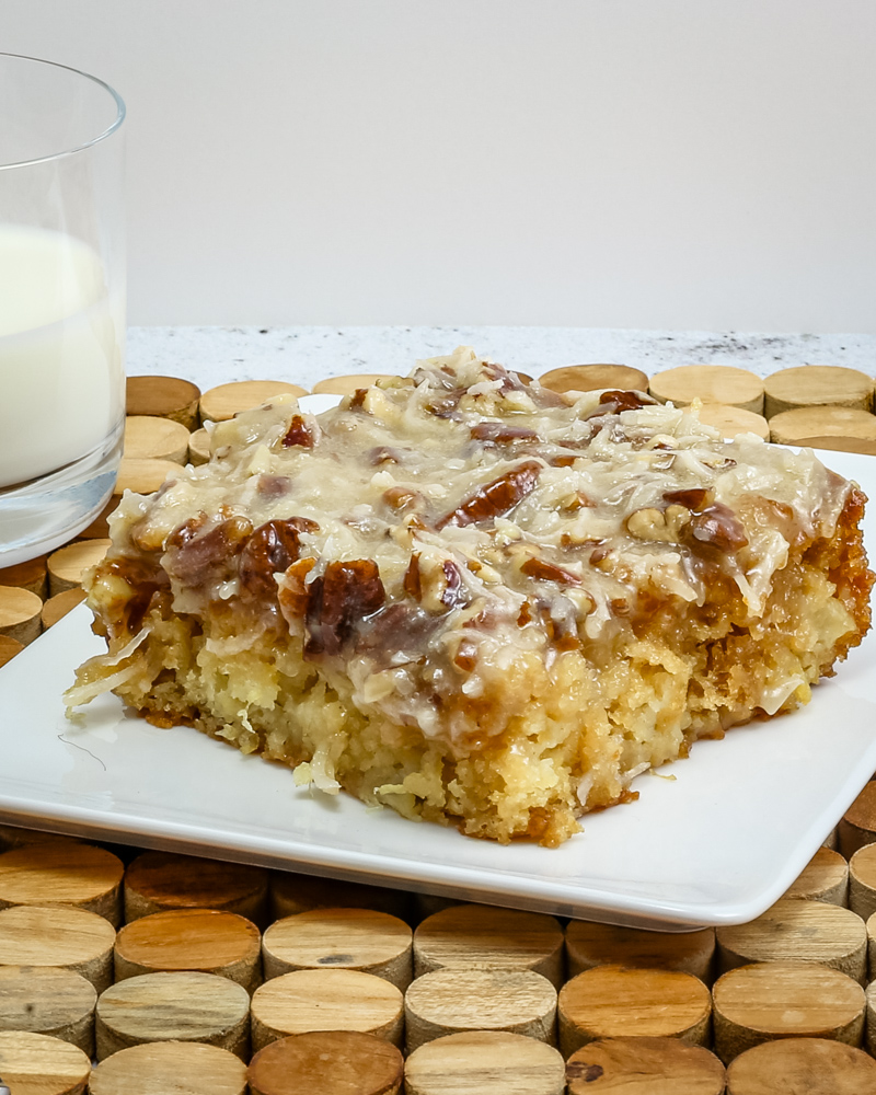 a slice of Cajun cake on a plate with a glass of milk